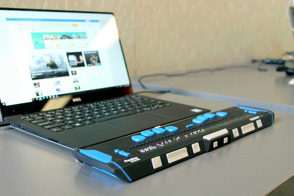 Laptop computer with an accessible keyboard attached, sitting on a counter top.