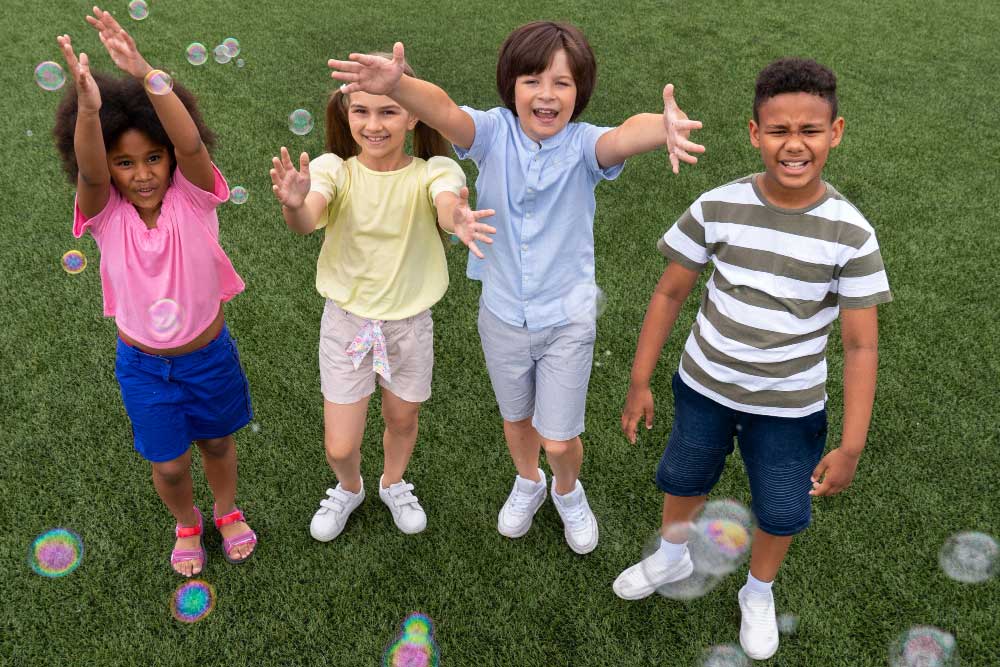 Group of smiling children outdoors on a field.